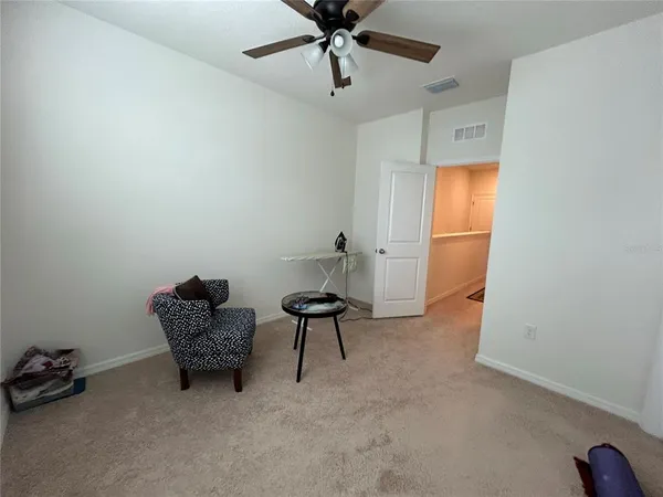 a living room with furniture and a ceiling fan