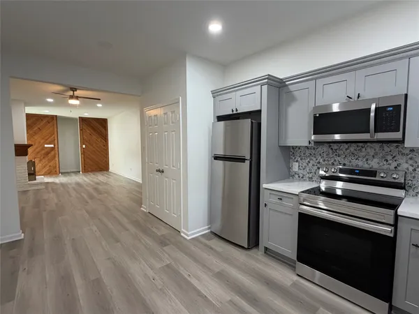 a kitchen with a refrigerator and a stove top oven