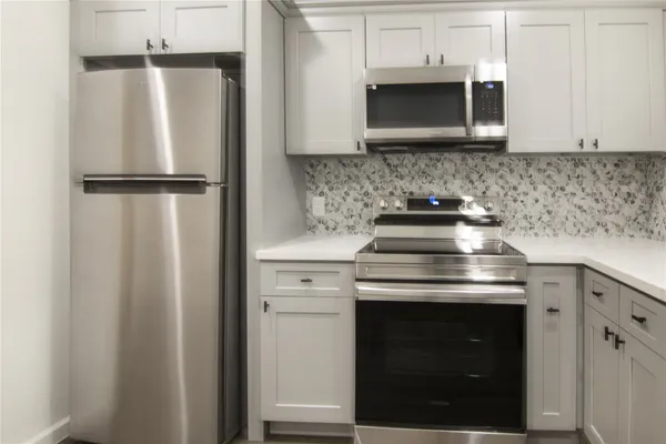 a kitchen with stainless steel appliances wooden cabinets and a stove top oven