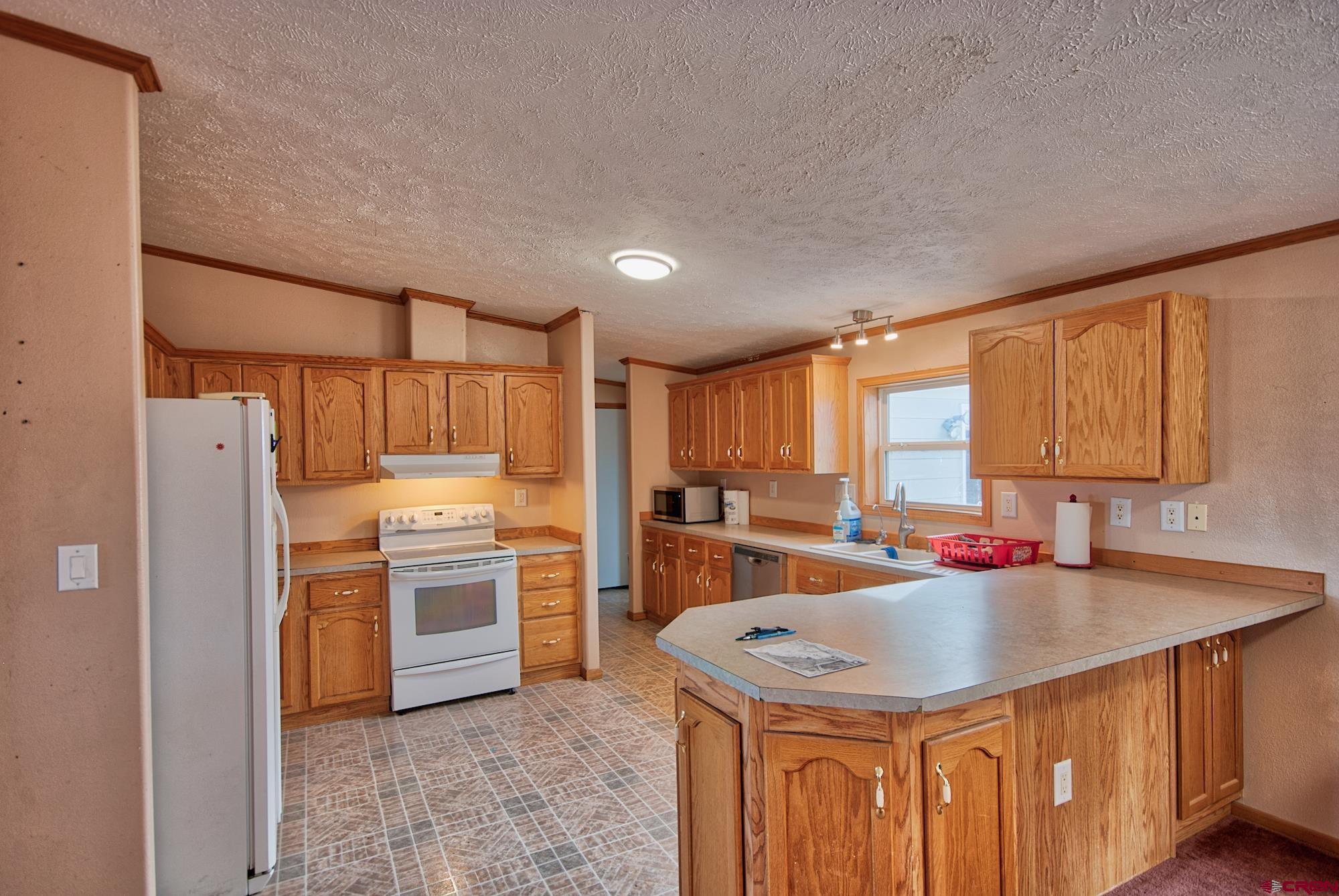 21548 F Road Delta, CO 81416 - Photo 4 of 21 a kitchen with a sink stove and refrigerator