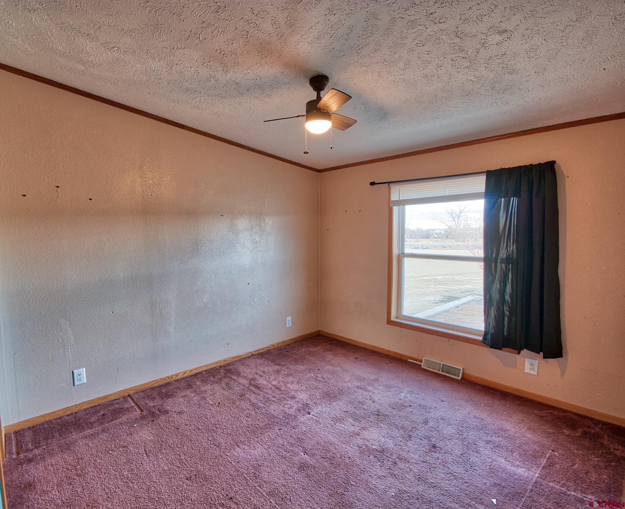 21548 F Road Delta, CO 81416 - Photo 7 of 21 an empty room with chandelier fan and windows