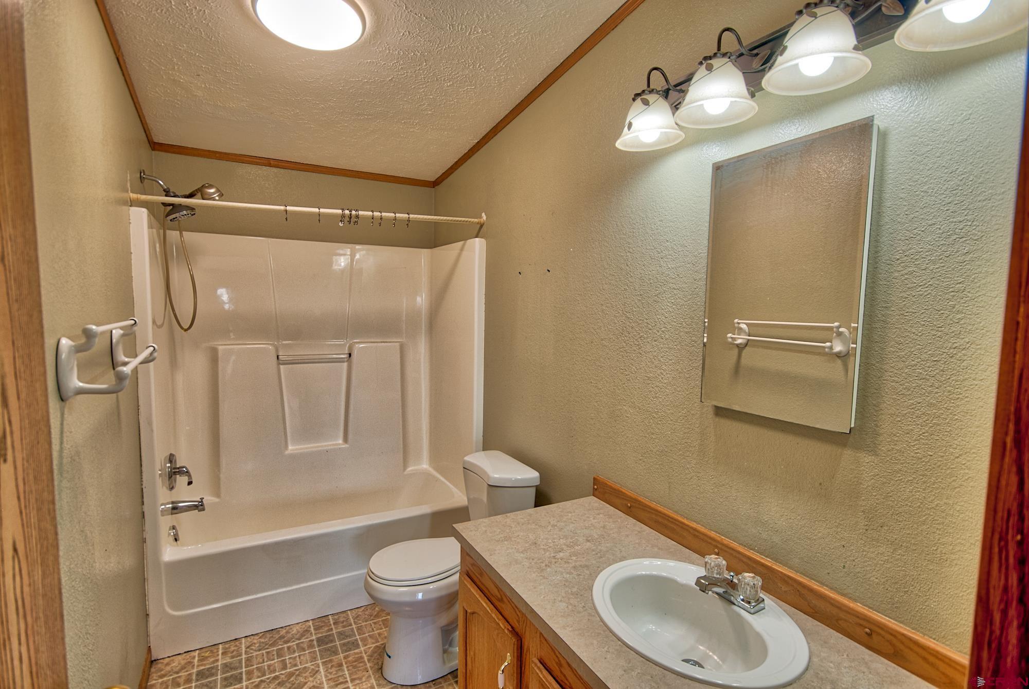 21548 F Road Delta, CO 81416 - Photo 9 of 21 a bathroom with a granite countertop sink toilet and shower