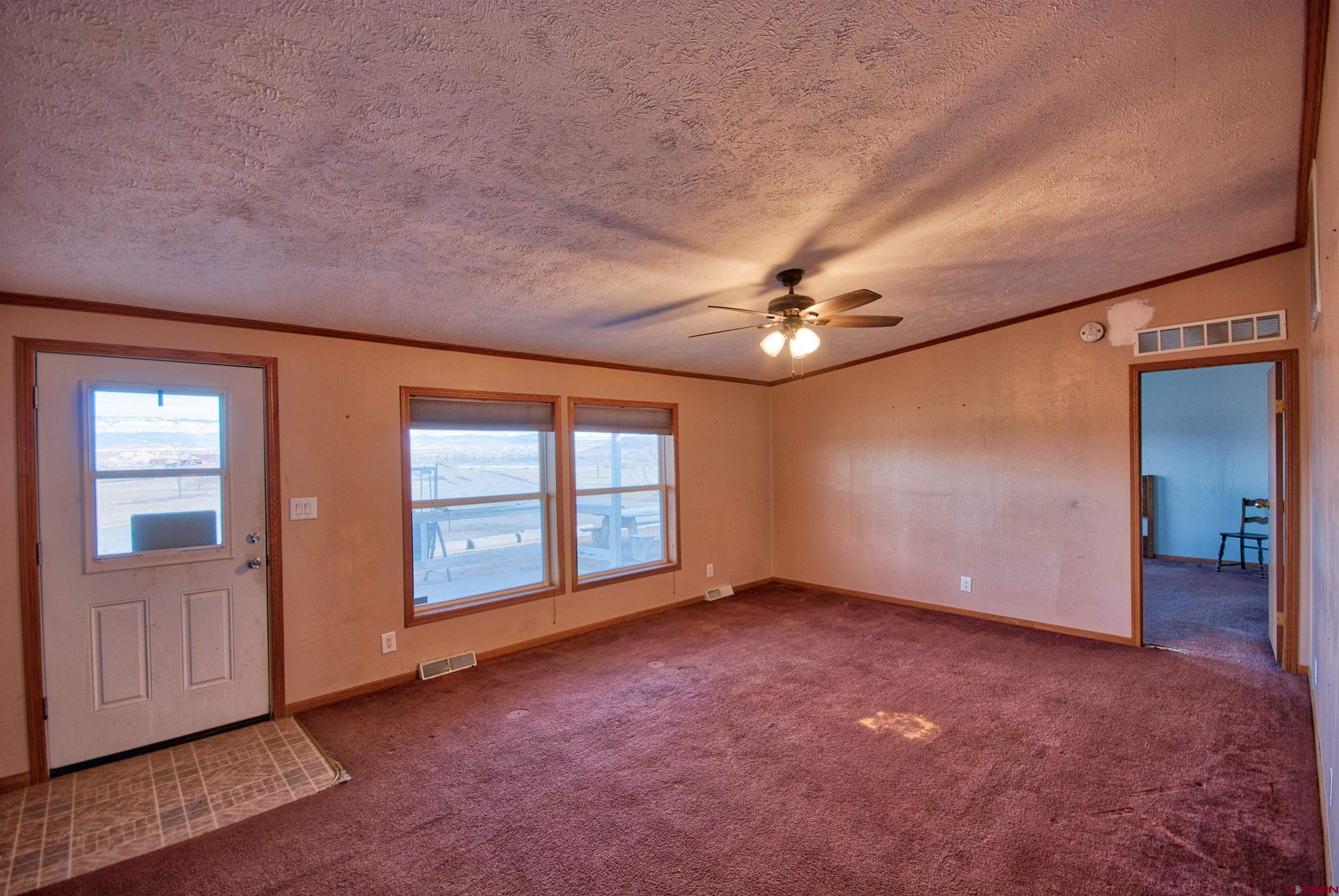 21548 F Road Delta, CO 81416 - Photo 10 of 21 an empty room with windows and ceiling fan