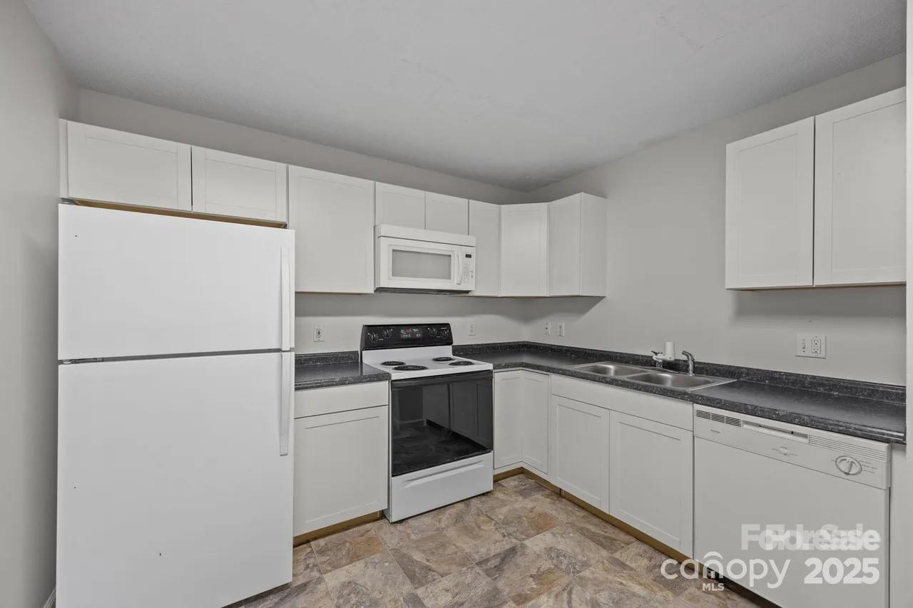 6 Azalea Road, Unit C Arden, NC 28704 - Photo 5 of 11 a white refrigerator freezer sitting in a kitchen