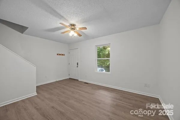an empty room with a window and a fan