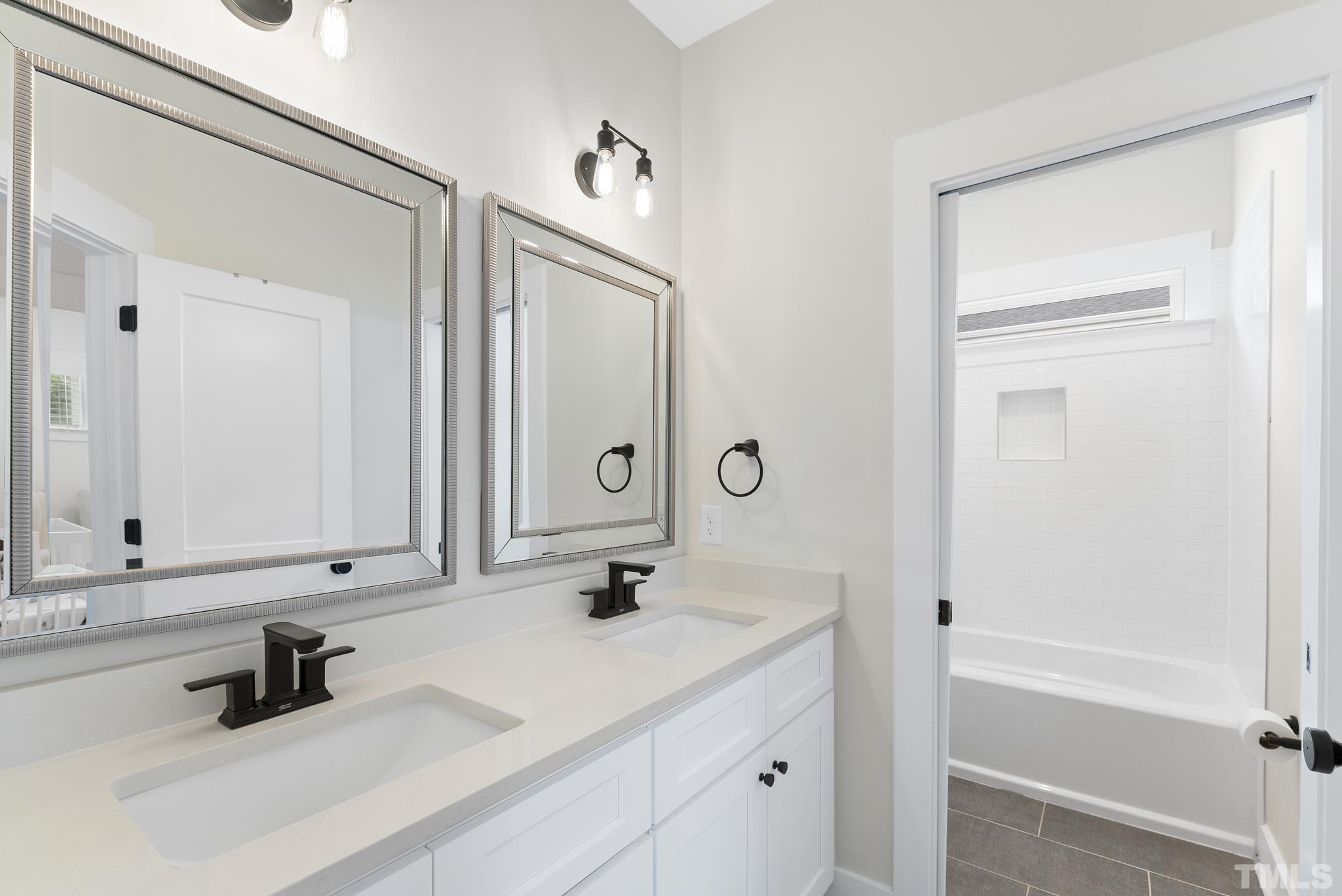 2320 Milburnie Road Raleigh, NC 27610 - Photo 30 of 40 a bathroom with a double vanity sink mirror and