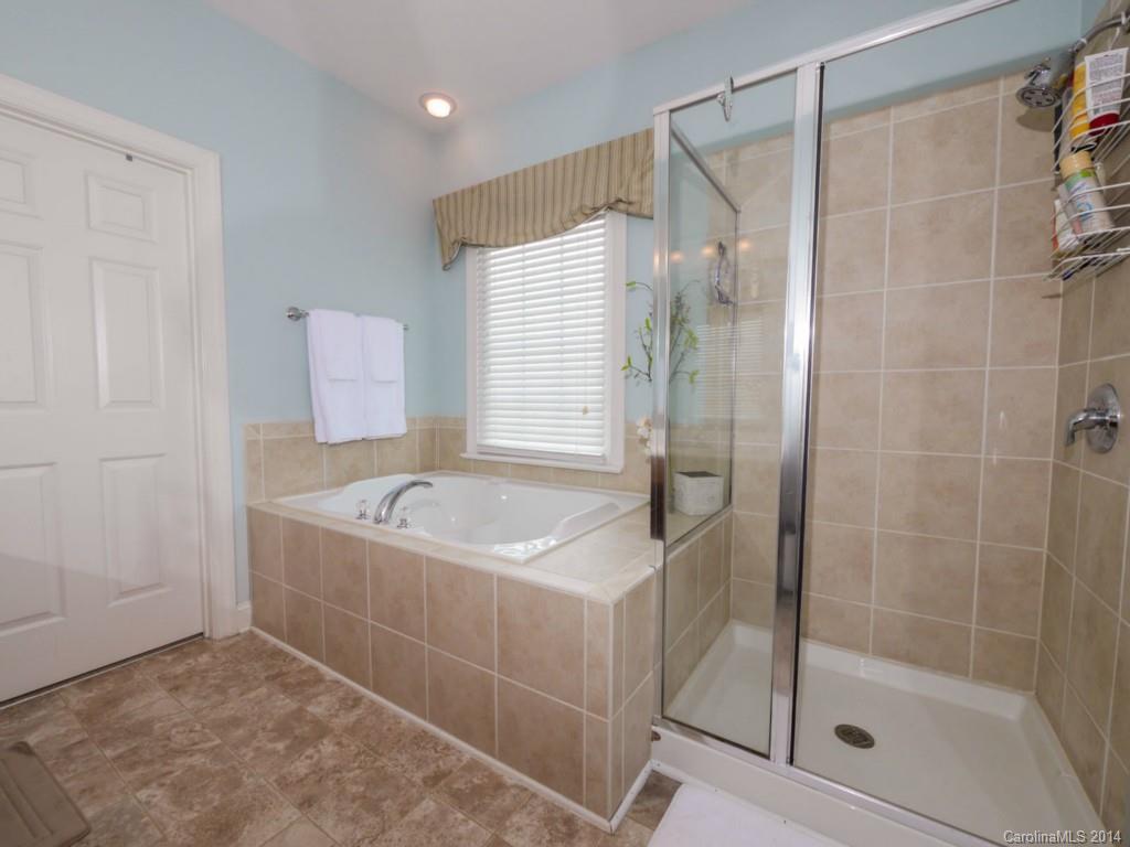 411 Bull Finch Bend Fort Mill, SC 29708 - Photo 12 of 22 a bathroom with a tub a sink and a shower