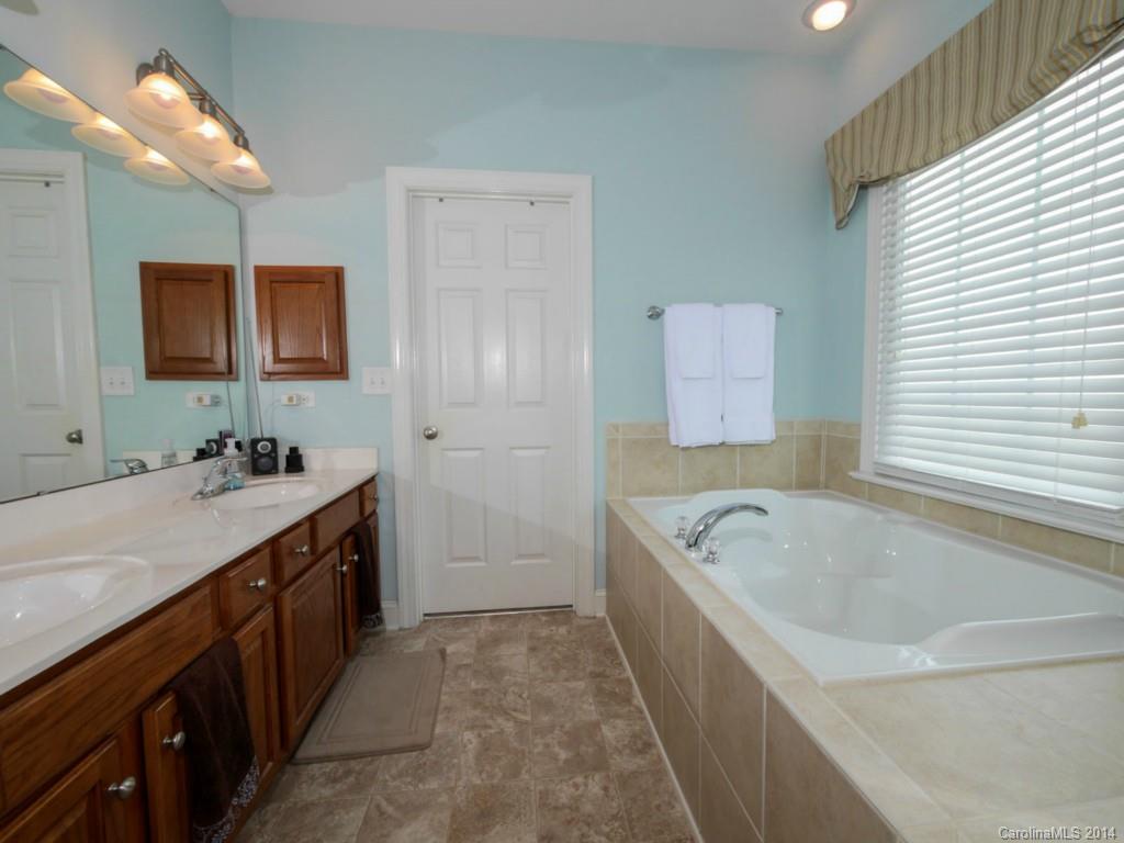 411 Bull Finch Bend Fort Mill, SC 29708 - Photo 13 of 22 a bathroom with a tub a double vanity sink and mirror
