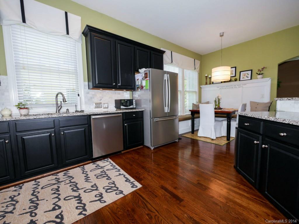 411 Bull Finch Bend Fort Mill, SC 29708 - Photo 5 of 22 a kitchen with stainless steel appliances granite countertop a refrigerator a sink dishwasher a stove with wooden cabinets and floor