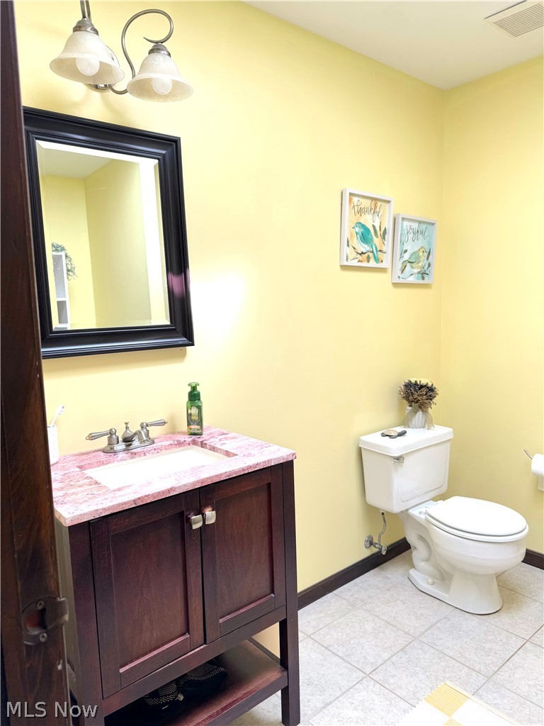 3906 Webb Road Ravenna, OH 44266 - Photo 24 of 33 Bathroom featuring a vanity with a red marble-look countertop, dark wood-finish cabinetry, and brushed nickel hardware