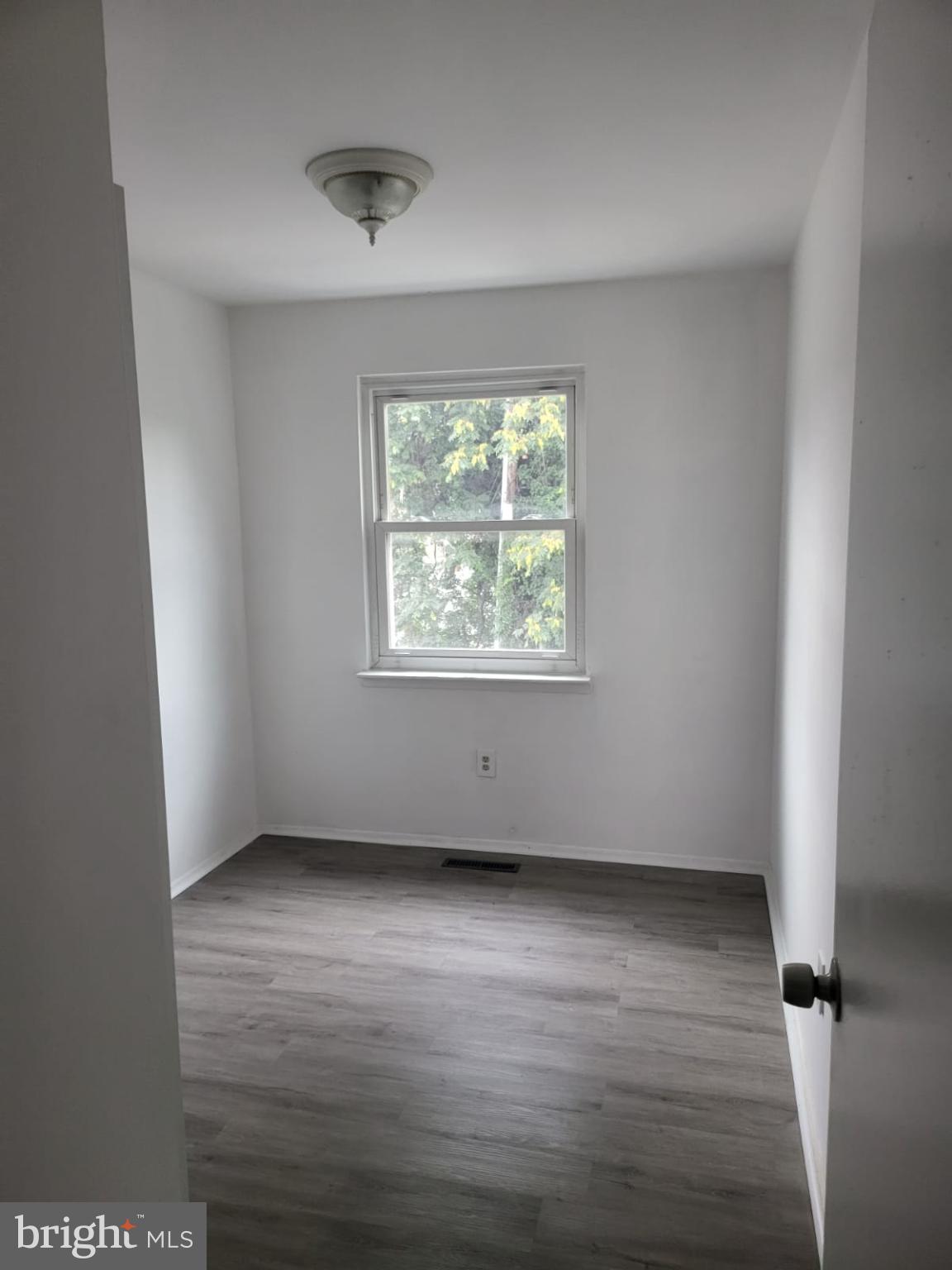 1129 Willinger Court Baltimore, MD 21202 - Photo 6 of 26 an empty room with wooden floor and windows
