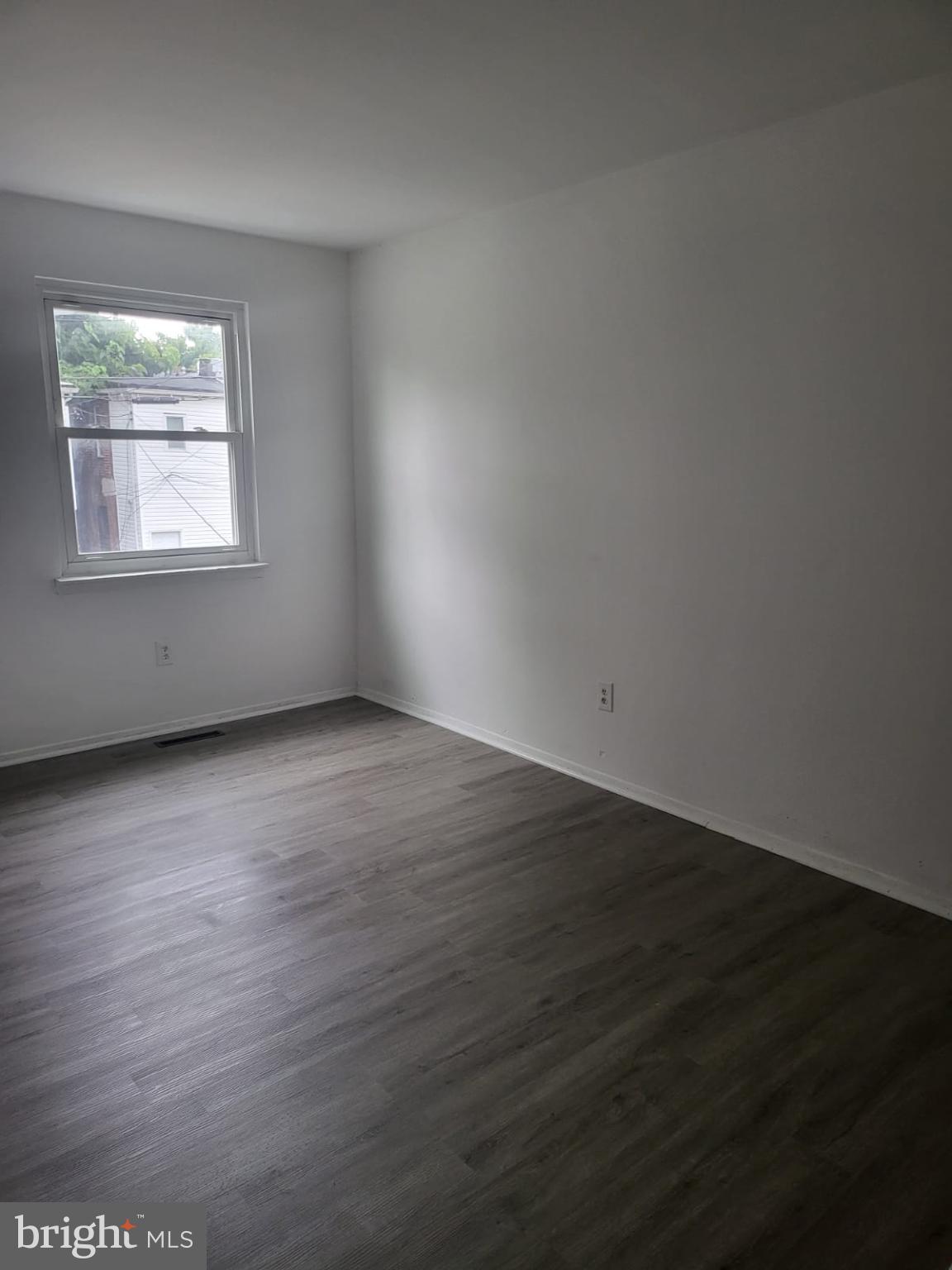 1129 Willinger Court Baltimore, MD 21202 - Photo 7 of 26 an empty room with wooden floor and windows