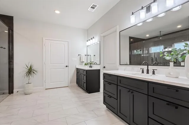 a spacious bathroom with a double vanity sink a mirror and a bathtub
