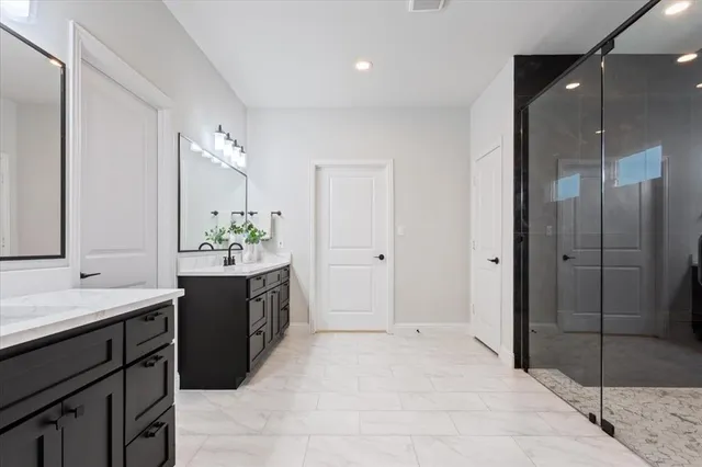 a spacious bathroom with a shower sink and mirror