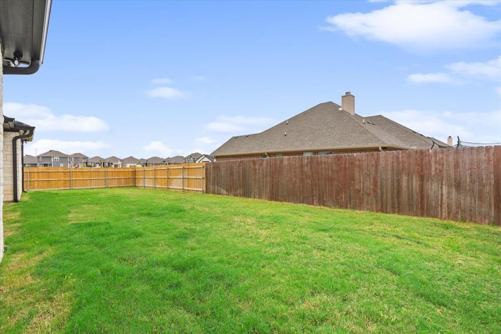 959 Gallant Fox Hewitt, TX 76643 - Photo 32 of 38 a view of a backyard with a barbeque and wooden fence