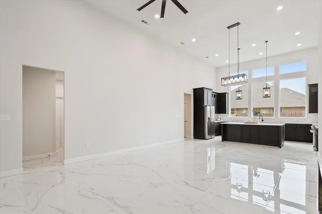 a large kitchen with a sink stainless steel appliances and cabinets