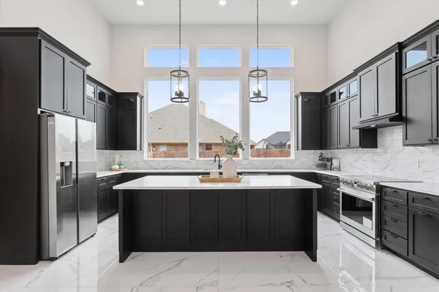 a kitchen with stainless steel appliances granite countertop a sink and a refrigerator