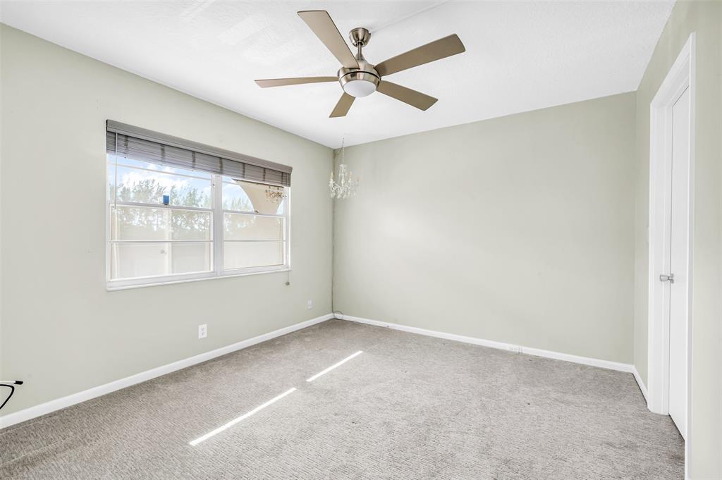 1703 Andros Isle, Unit G4 Coconut Creek, FL 33066 - Photo 13 of 33 an empty room with a window and a ceiling fan