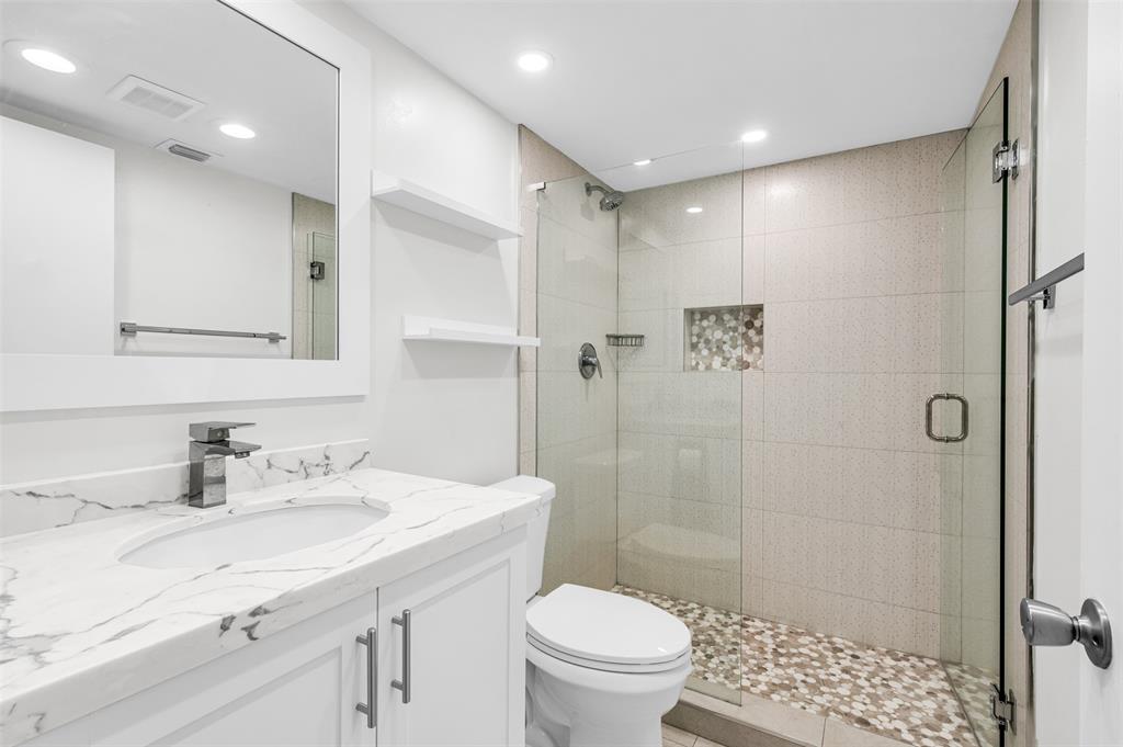 1703 Andros Isle, Unit G4 Coconut Creek, FL 33066 - Photo 14 of 33 a bathroom with a sink toilet a mirror and shower