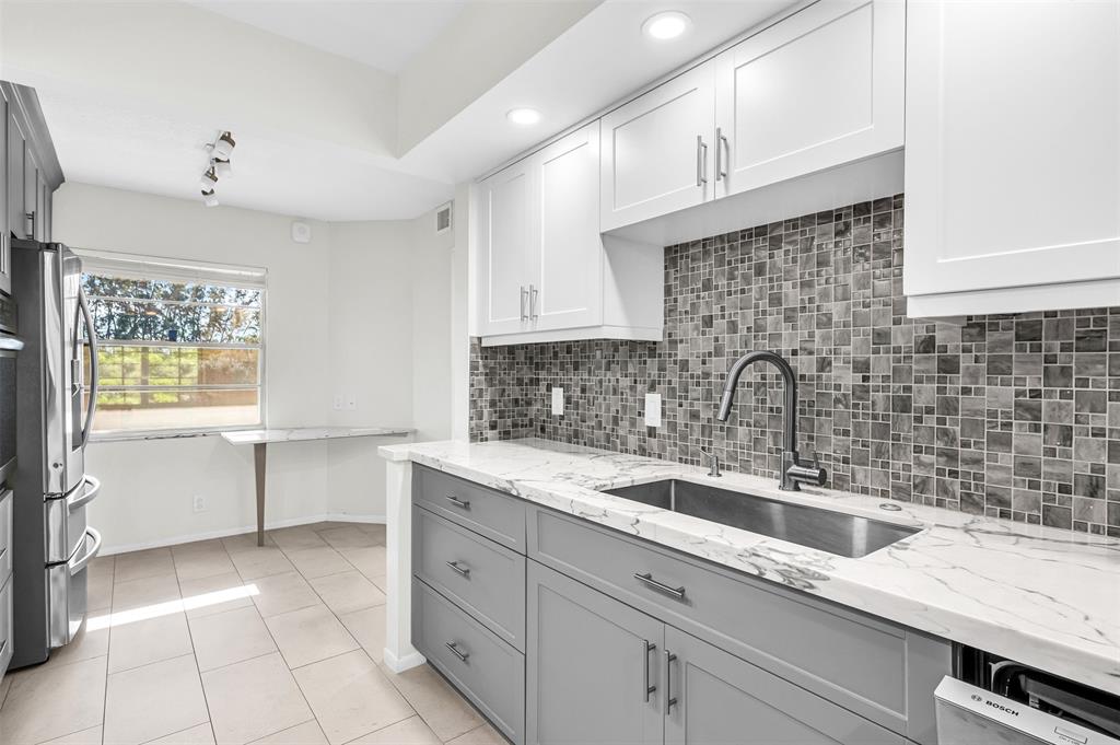 1703 Andros Isle, Unit G4 Coconut Creek, FL 33066 - Photo 5 of 33 a kitchen with a sink cabinets and window