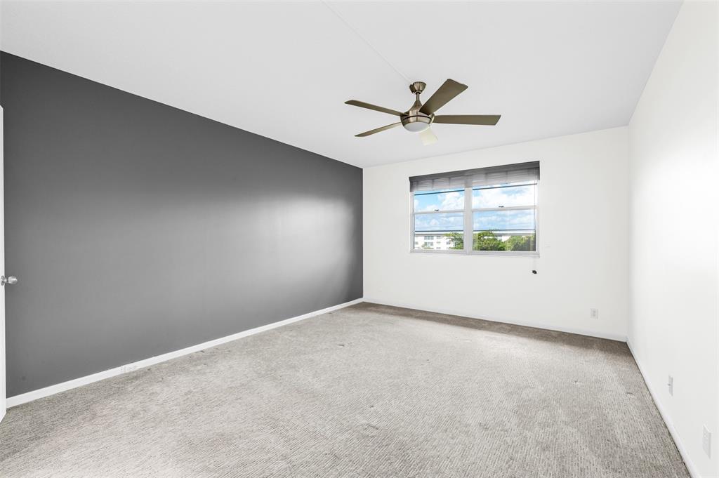 1703 Andros Isle, Unit G4 Coconut Creek, FL 33066 - Photo 8 of 33 an empty room with windows and fan