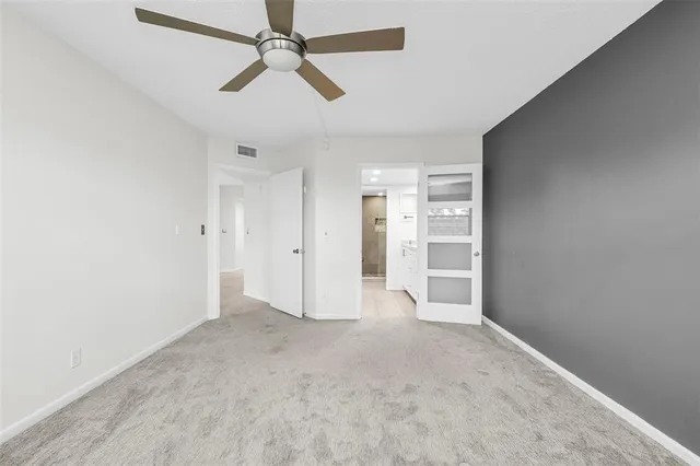 an empty room with closet and windows