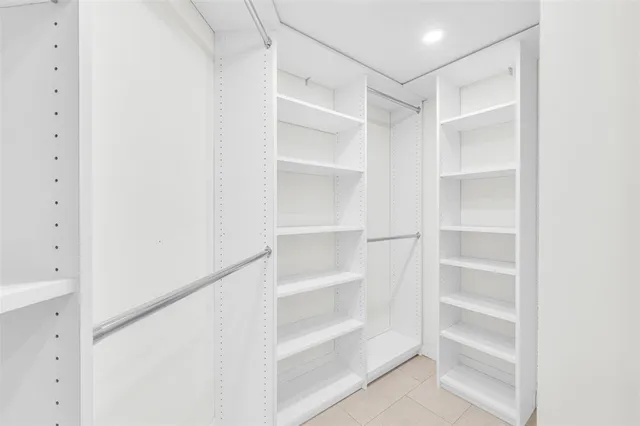 a view of walk in closet with empty racks
