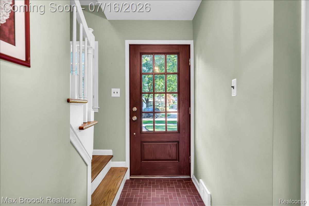 1292 Yorkshire Road Birmingham, MI 48009 - Photo 4 of 47 Entryway featuring a rich wood-finish door with glass panels, a white staircase with wood-finish treads, light-toned wall paint, and patterned tile flooring