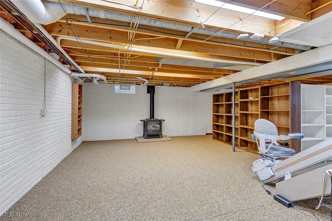 41575 Russia Road Elyria, OH 44035 - Photo 22 of 37 Below grade area with a wood stove, nature stone floors, and brick wall