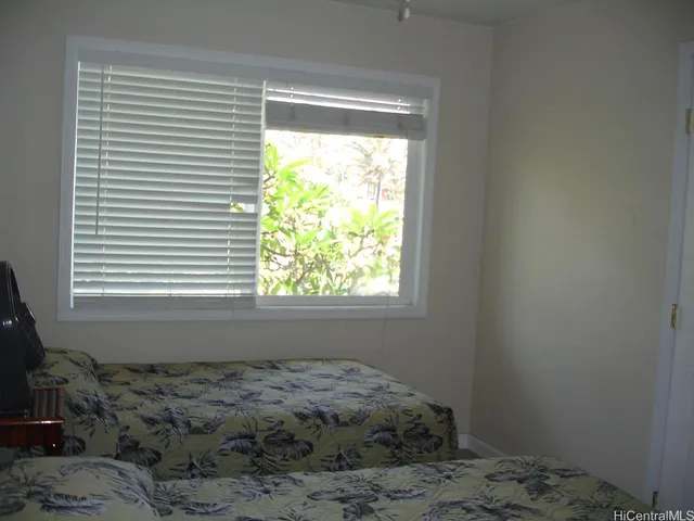 a bed sitting in a bedroom next to a window