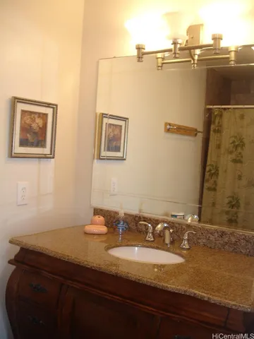 a bathroom with a granite countertop sink and a mirror