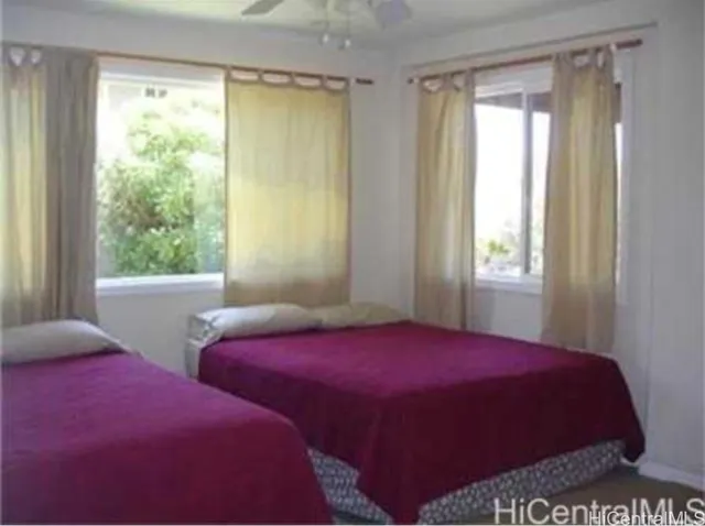 a bedroom with two beds and a window