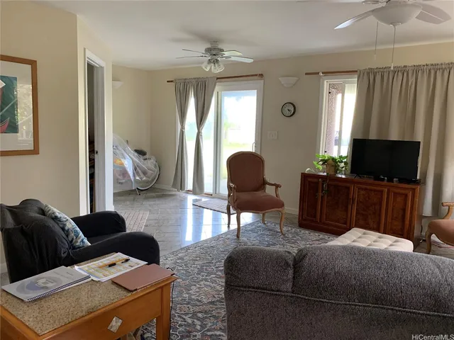 a living room with furniture a ceiling fan and a window