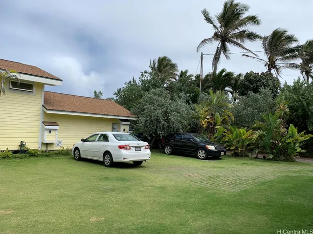 a car parked in front of a house with a yard