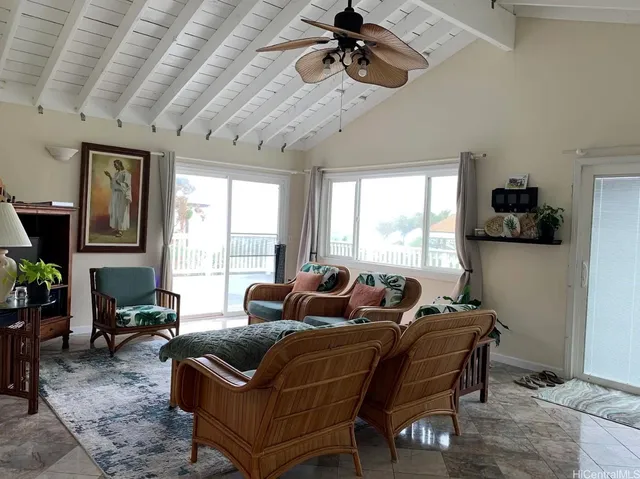 a living room with furniture a flat screen tv and a large window