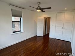 102-12 65th Avenue, Unit 43C Queens, NY 11375 - Photo 12 of 15 an empty room with wooden floor a ceiling fan and windows