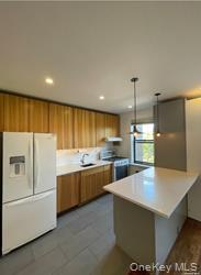 102-12 65th Avenue, Unit 43C Queens, NY 11375 - Photo 2 of 15 a large kitchen with stainless steel appliances a large counter top and a stove