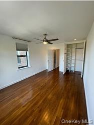 102-12 65th Avenue, Unit 43C Queens, NY 11375 - Photo 4 of 15 an empty room with wooden floor and windows