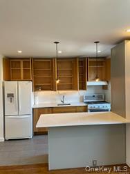 102-12 65th Avenue, Unit 43C Queens, NY 11375 - Photo 7 of 15 a kitchen with kitchen island a sink and refrigerator