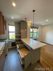 102-12 65th Avenue, Unit 43C Queens, NY 11375 - Photo 8 of 15 a kitchen with kitchen island a sink stainless steel appliances and window