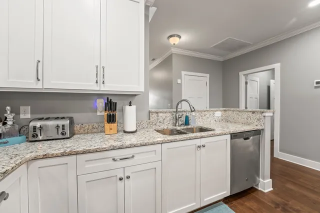 a kitchen with granite countertop white cabinets and sink