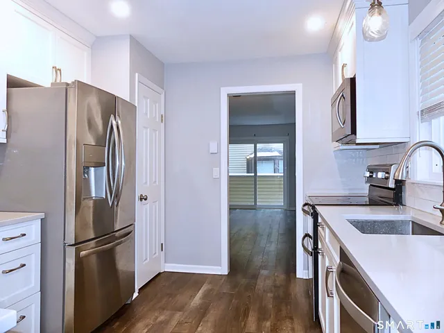 a kitchen with a refrigerator sink and cabinets