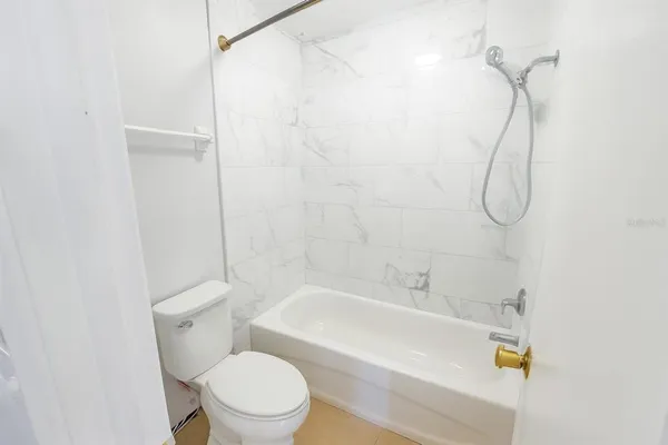 a bathroom with a toilet and a bath tub