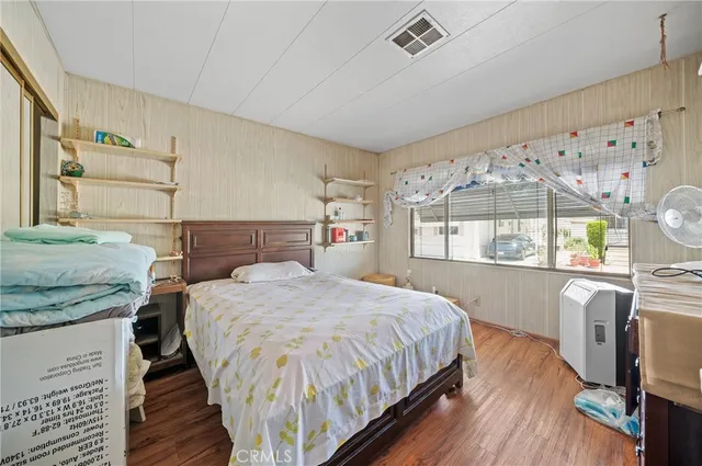 a bedroom with a bed and a large mirror on the dresser