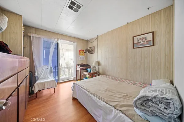 a bedroom with a bed and wooden floor