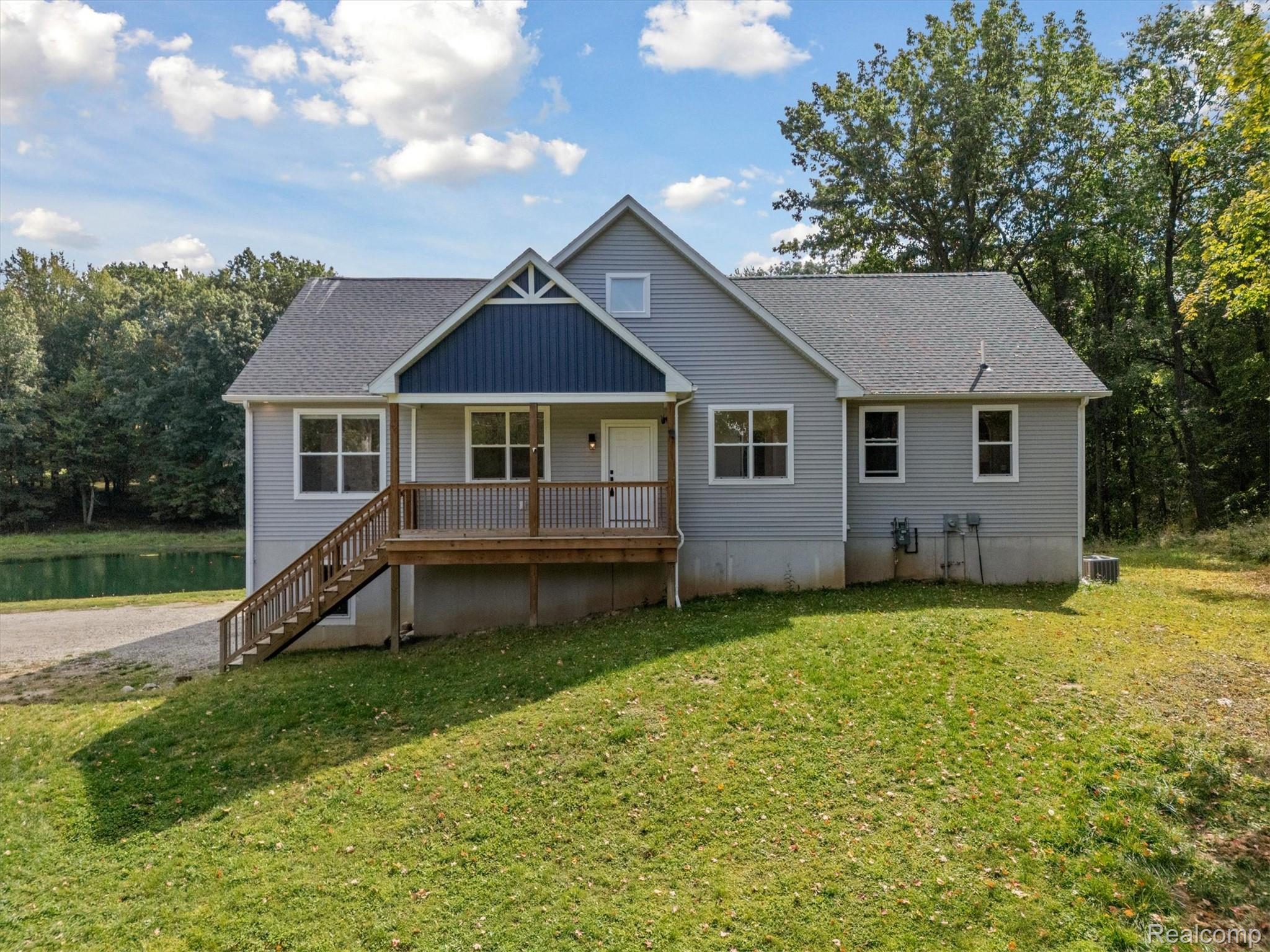 441 West Dryden Road Metamora, MI 48455 - Photo 2 of 62 View of front of house featuring a porch, a front yard, roof with shingles, and stairway