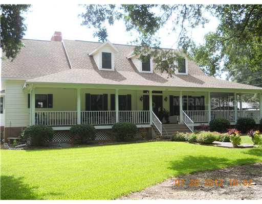 a view of a house with a yard and sitting area