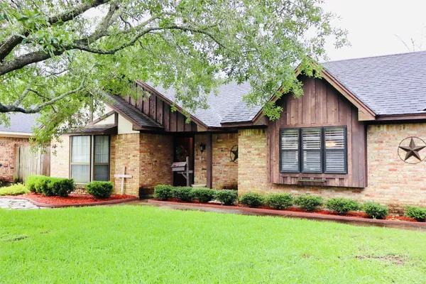 a front view of a house with a garden and plants