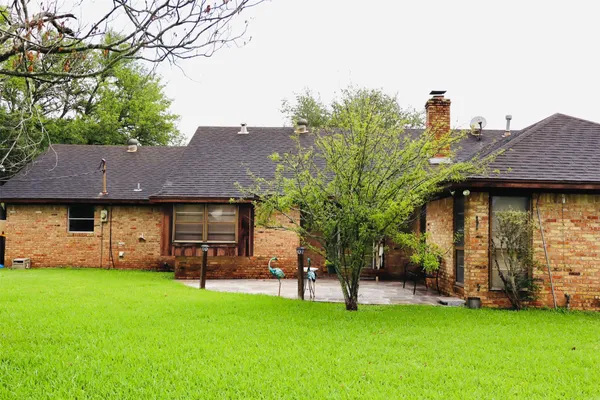 a view of a house with backyard and a tree