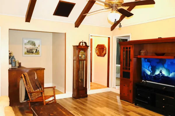 a view of a hallway with wooden floor and furniture